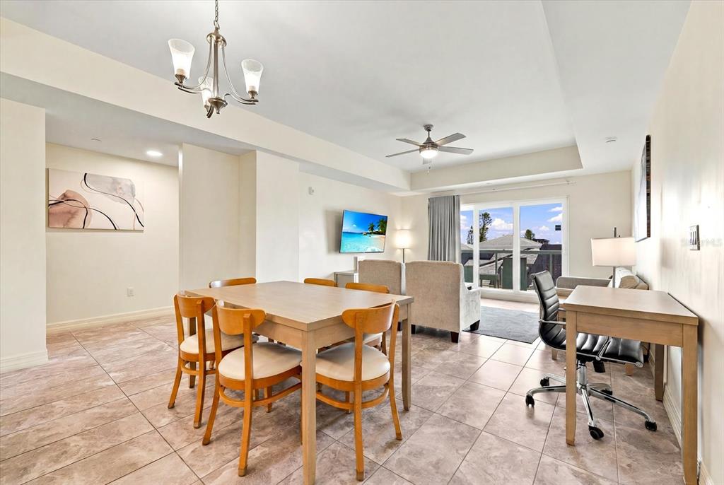 A kitchen with dark wood cabinets and granite countertops opens into a living area — 24 AVALON STREET UNIT 405, CLEARWATER BEACH, FL