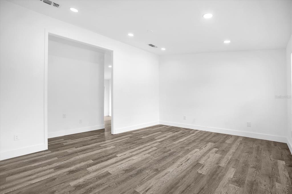 An empty room with white walls, recessed lighting, and wood-look flooring — 1730 AVENUE C NE, WINTER HAVEN, FL