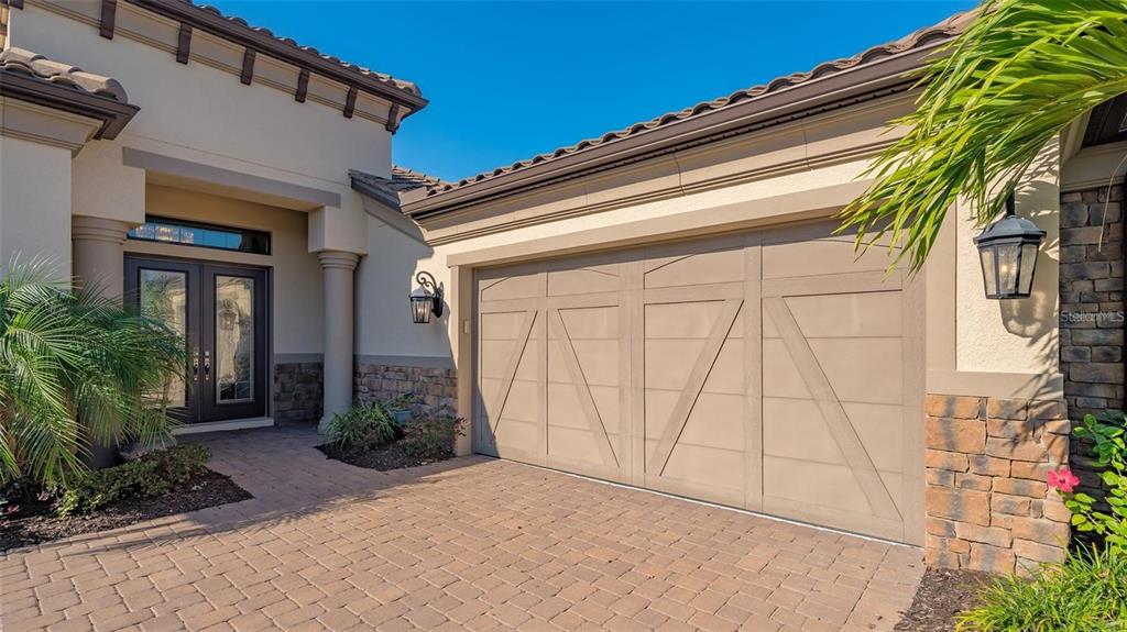The exterior of a house features a paved driveway, a garage, and a front entryway — 4714 CABREO COURT, BRADENTON, FL