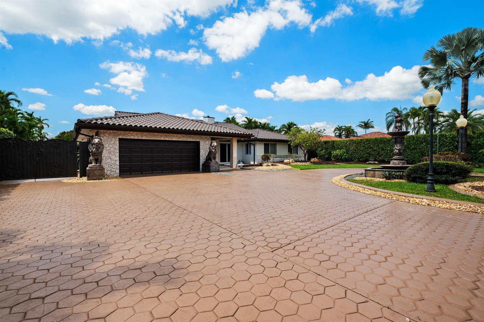 A house exterior with a large paved driveway, a fountain, and two lion statues — 2840 SW 128th Avenue, Miami FL 33175, MIAMI, FL