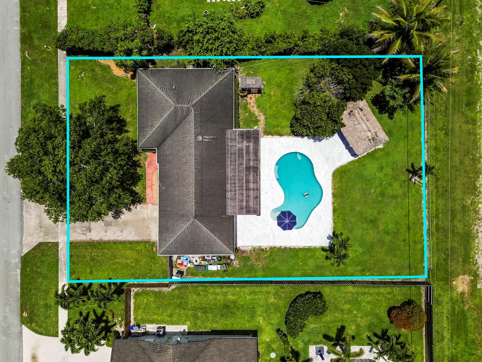 Aerial view of a house with a pool, patio, and backyard within a fenced lot — 7635 Oakmont Drive, Lake Worth FL 33467, LAKE WORTH, FL