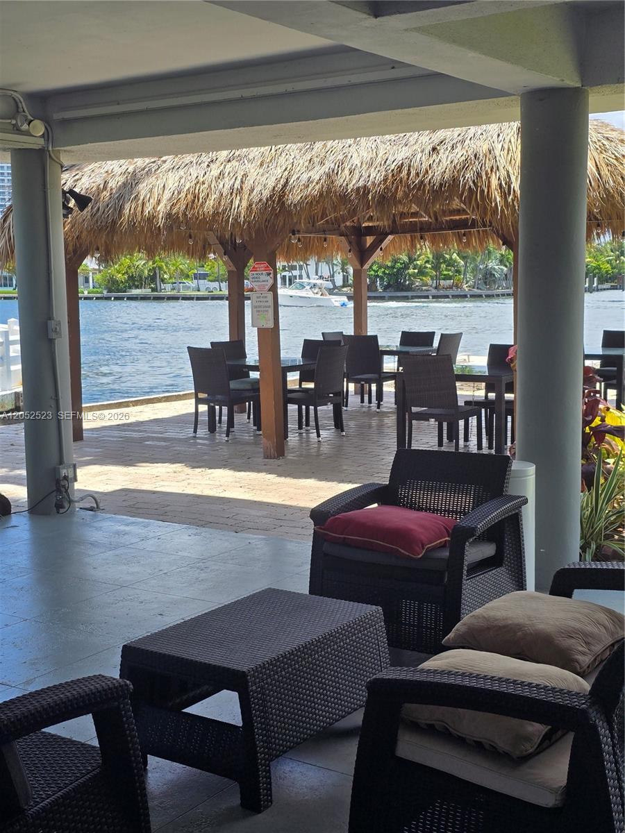 A covered patio features outdoor furniture and a thatched-roof gazebo overlooking a waterway — 3177 S Ocean Dr # 217, Hallandale Beach FL 33009, HALLANDALE BEACH, FL