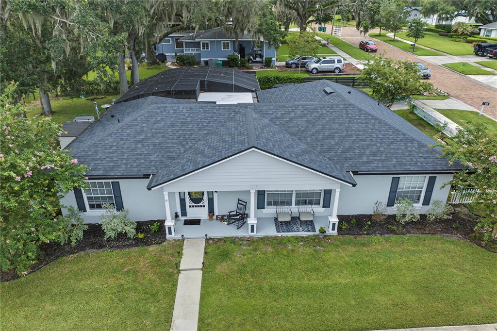 An aerial view of a single-story house with a dark shingled roof and porch — 64 E CREST AVENUE, WINTER GARDEN, FL