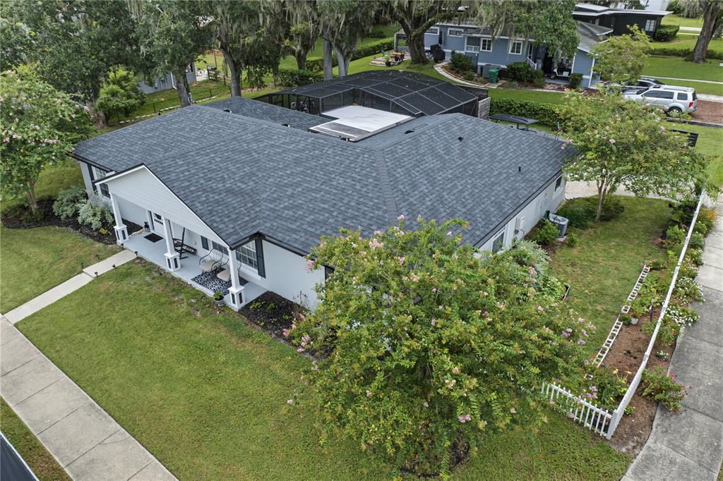 An aerial view shows a single-story house with a dark shingled roof and screened-in patio — 64 E CREST AVENUE, WINTER GARDEN, FL