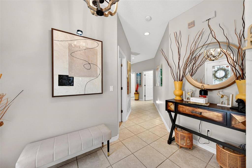An entryway features a tiled floor, a console table, a bench, and wall art — 2125 VELVET LEAF DRIVE, OCOEE, FL