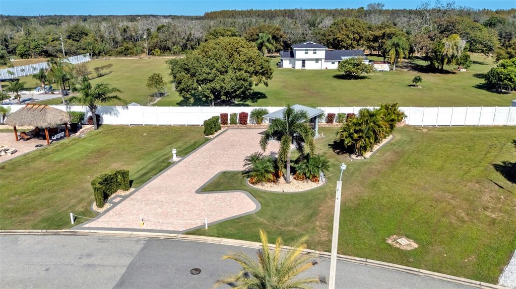 An aerial view shows a paved driveway, a small gazebo, and a house on a lawn — 2947 WOOD DUCK DRIVE, POLK CITY, FL