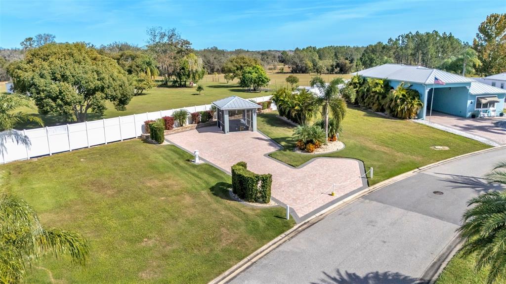 An aerial view shows a paved driveway, a gazebo, and a house with a blue exterior — 2947 WOOD DUCK DRIVE, POLK CITY, FL