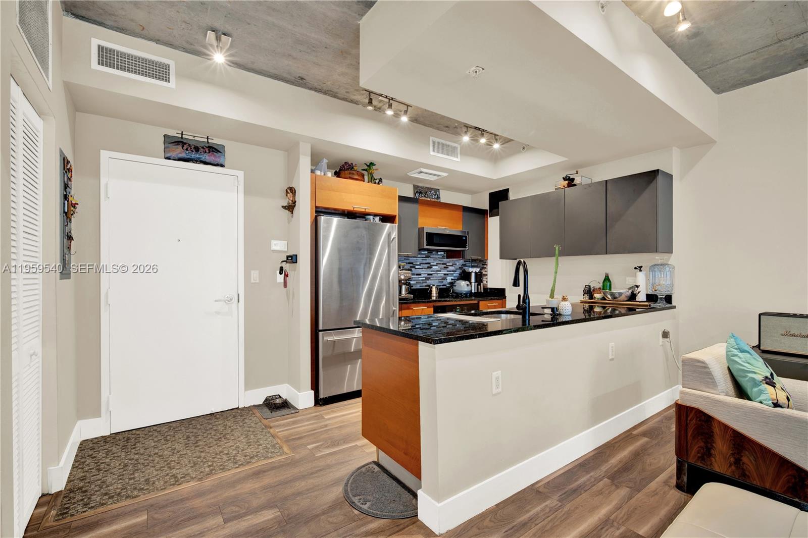 A kitchen with stainless steel appliances, dark cabinets, and a granite island countertop — 3449 NE 1st Ave # 110, Miami FL 33137, MIAMI, FL