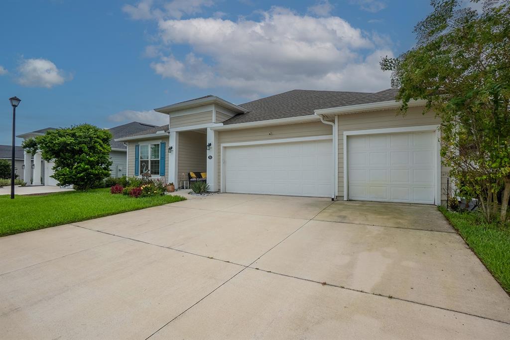 An entryway features a wooden cabinet, an elephant figurine, wall art, and double glass doors — 524 GRAND LANDINGS PARKWAY, PALM COAST, FL
