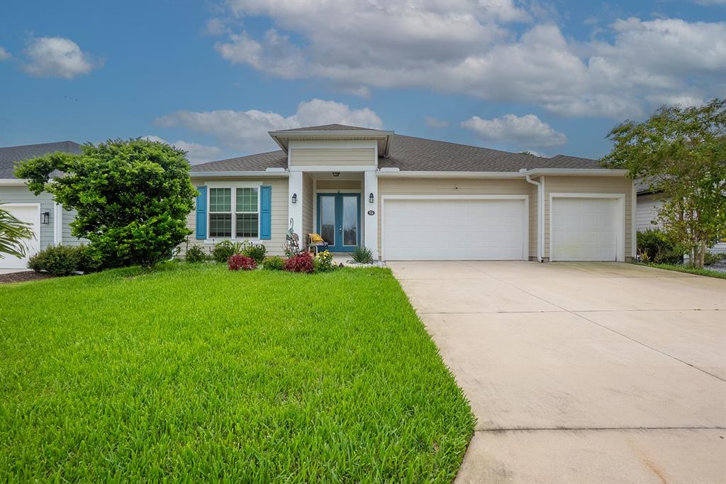 A dining room with a wooden table, cane-back chairs, and a modern light fixture — 524 GRAND LANDINGS PARKWAY, PALM COAST, FL