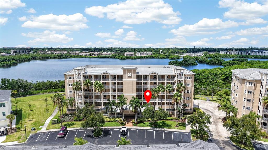 An aerial view shows a multi-story apartment building with palm trees and a parking lot — 10002 KEY HAVEN ROAD UNIT 204, SEMINOLE, FL