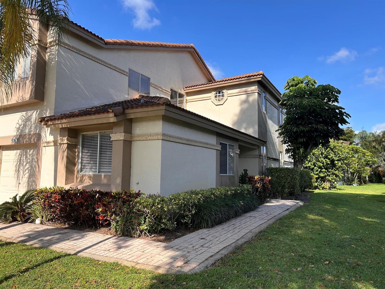 A two-story stucco townhouse with a tile roof, brick walkway, and landscaped front yard — 6754 Via Regina, Boca Raton FL 33433, BOCA RATON, FL