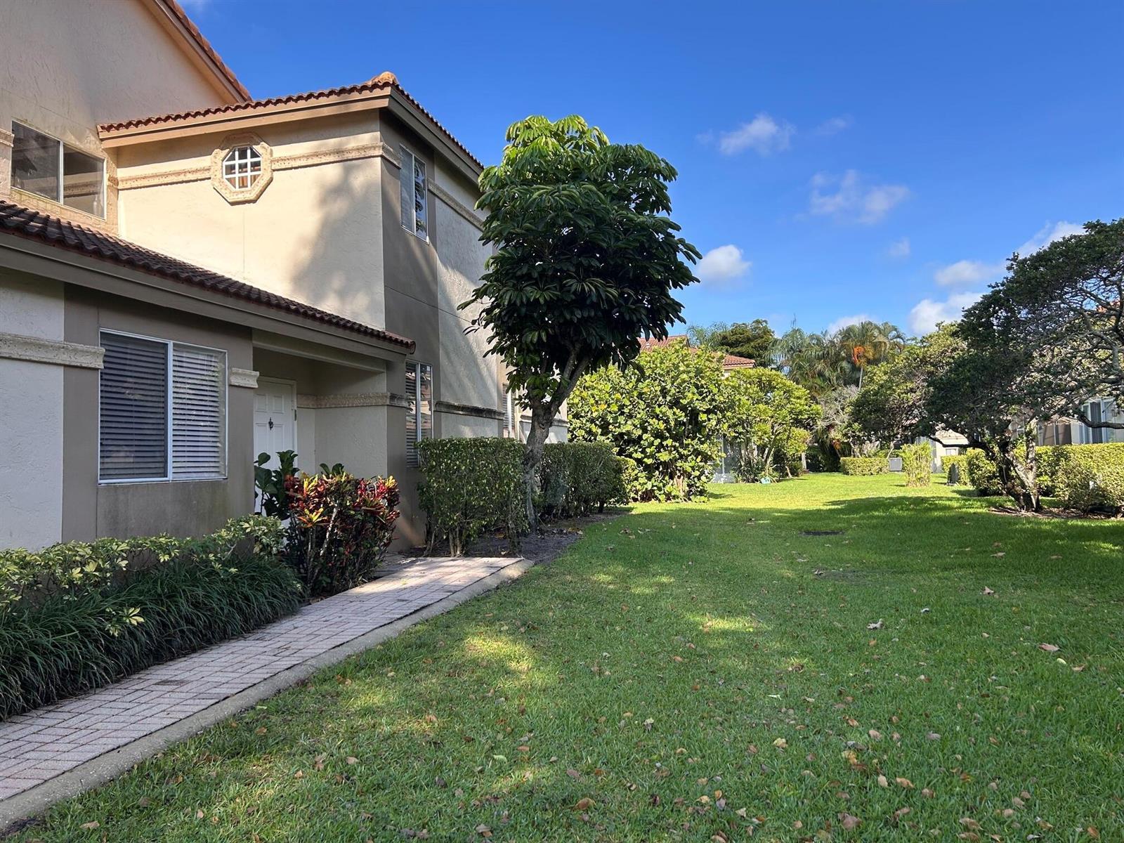 A two-story tan townhouse with a brick walkway and a large green lawn — 6754 Via Regina, Boca Raton FL 33433, BOCA RATON, FL