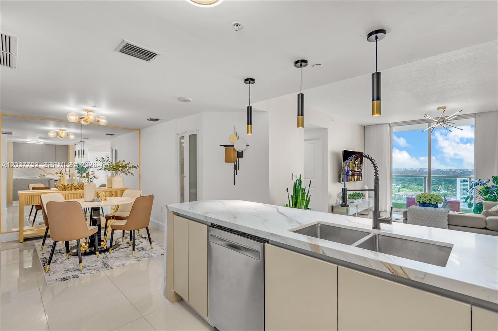 A modern kitchen with a marble island and stainless steel sink overlooks a dining area — 1250 S Miami Ave # 2305, Miami FL 33130, MIAMI, FL