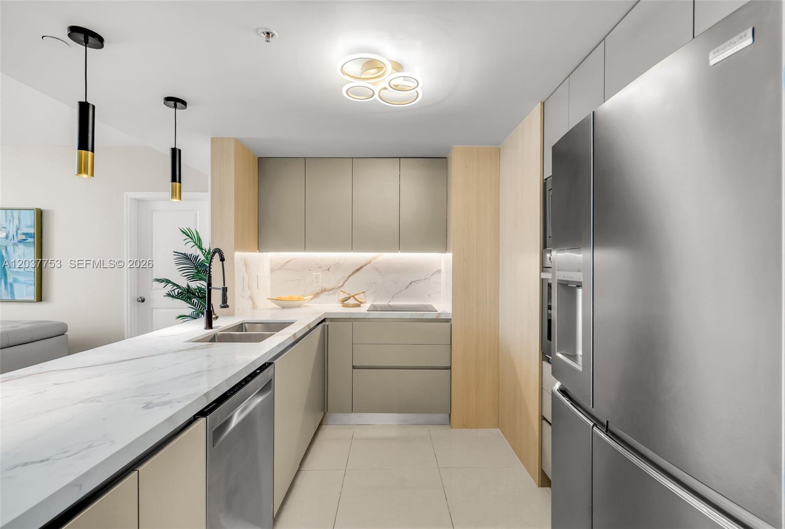 A modern kitchen features light wood cabinetry, marble countertops, and stainless steel appliances — 1250 S Miami Ave # 2305, Miami FL 33130, MIAMI, FL