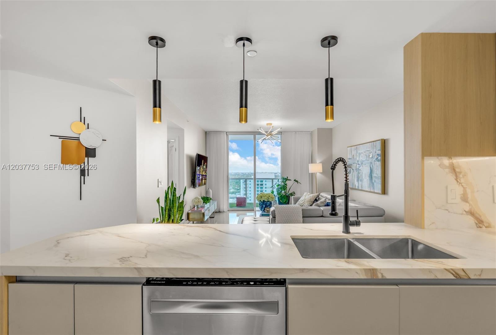 A kitchen island with a marble countertop overlooks a living room with a balcony view — 1250 S Miami Ave # 2305, Miami FL 33130, MIAMI, FL