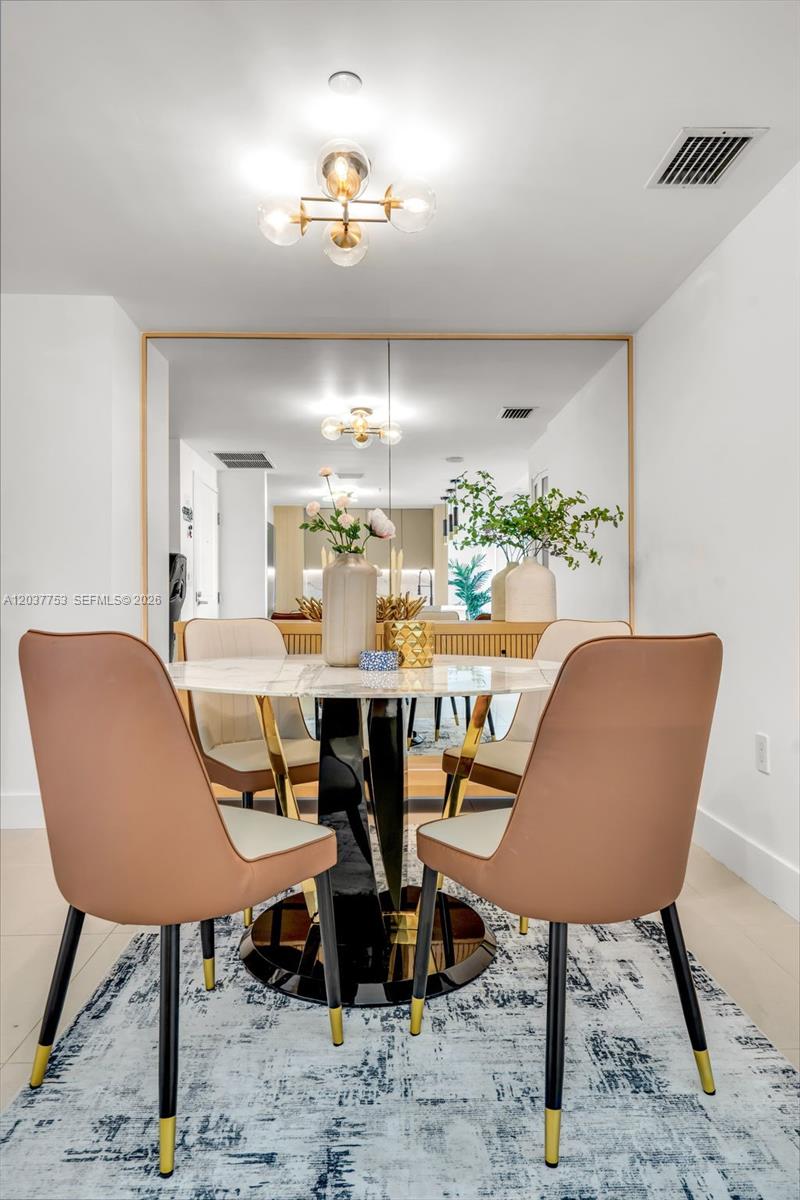 A dining room features a round marble table, four modern chairs, and a large mirror — 1250 S Miami Ave # 2305, Miami FL 33130, MIAMI, FL