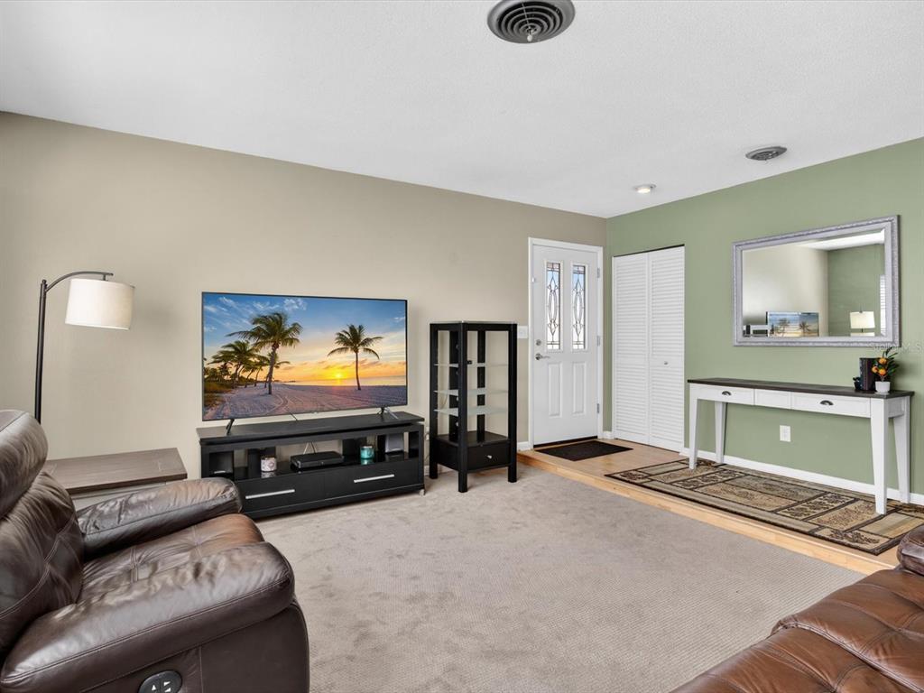 A living room features a television on a stand, a leather recliner, and an entryway — 2803 BANCHORY ROAD, WINTER PARK, FL