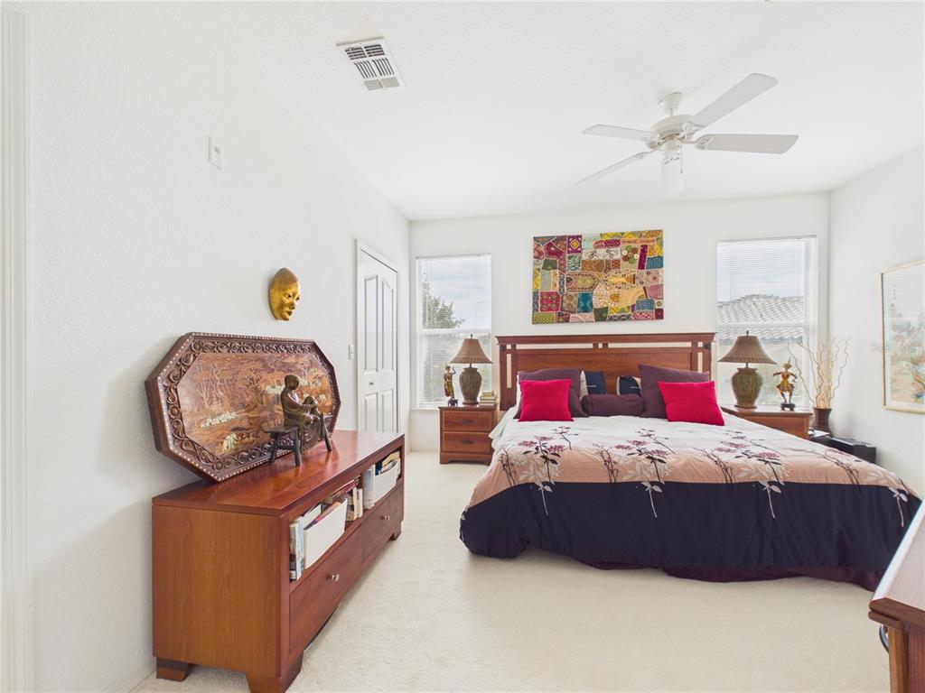 A bedroom features a wooden bed frame, matching nightstands, and a large wooden dresser — 8816 DUNES COURT UNIT 302, KISSIMMEE, FL