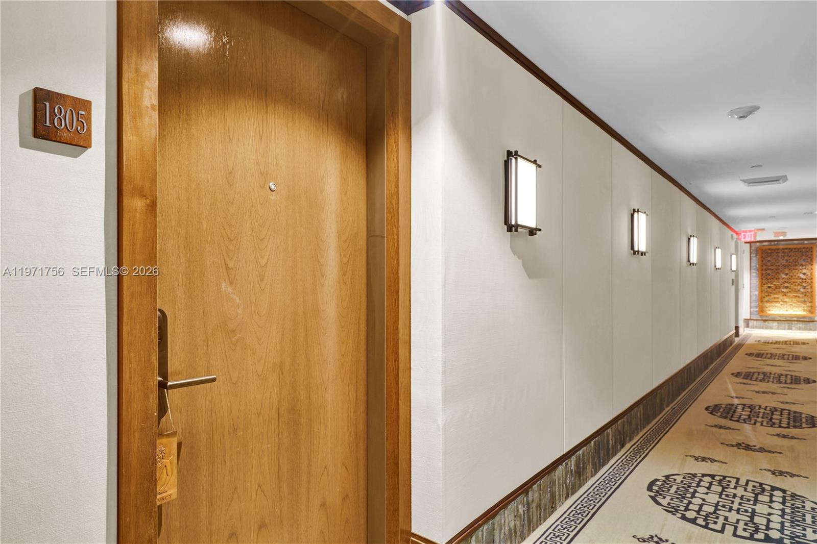 A wooden door marked 1805 opens into a hallway with wall sconces and patterned carpet — 101 20th St # 1805, Miami Beach FL 33139, MIAMI BEACH, FL