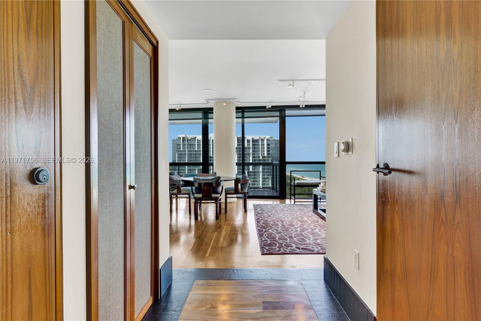 A view from a hallway into a living area with floor-to-ceiling windows overlooking the ocean — 101 20th St # 1805, Miami Beach FL 33139, MIAMI BEACH, FL