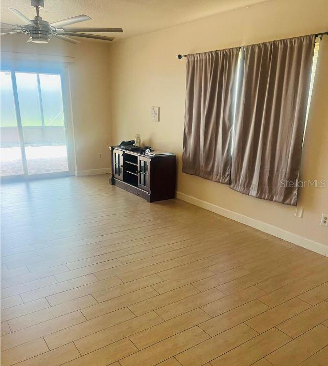 A living room features light wood-look tile flooring, a ceiling fan, and a sliding glass door — 5424 SERENE LANE, ORLANDO, FL