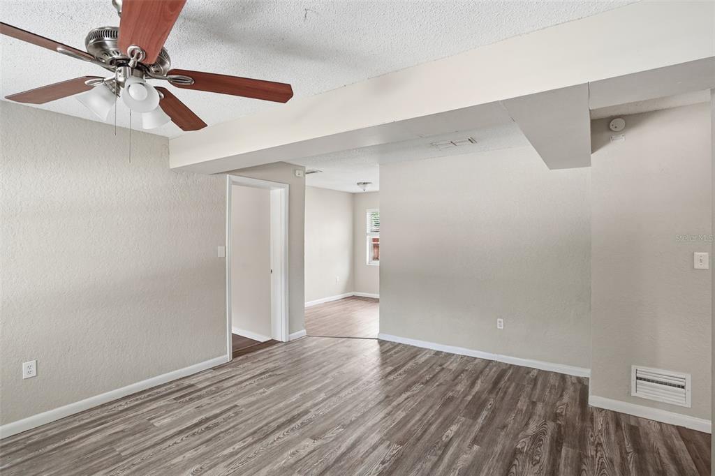 A room with wood-look flooring, a ceiling fan, and a doorway leading to another room — 1413 SUNRIDGE ROAD, ORLANDO, FL