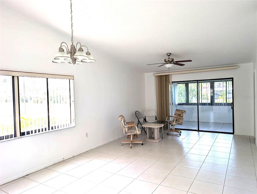 A bright room with white tile floors, a ceiling fan, and a dining area — 5716 12TH AVENUE W UNIT 5716, BRADENTON, FL