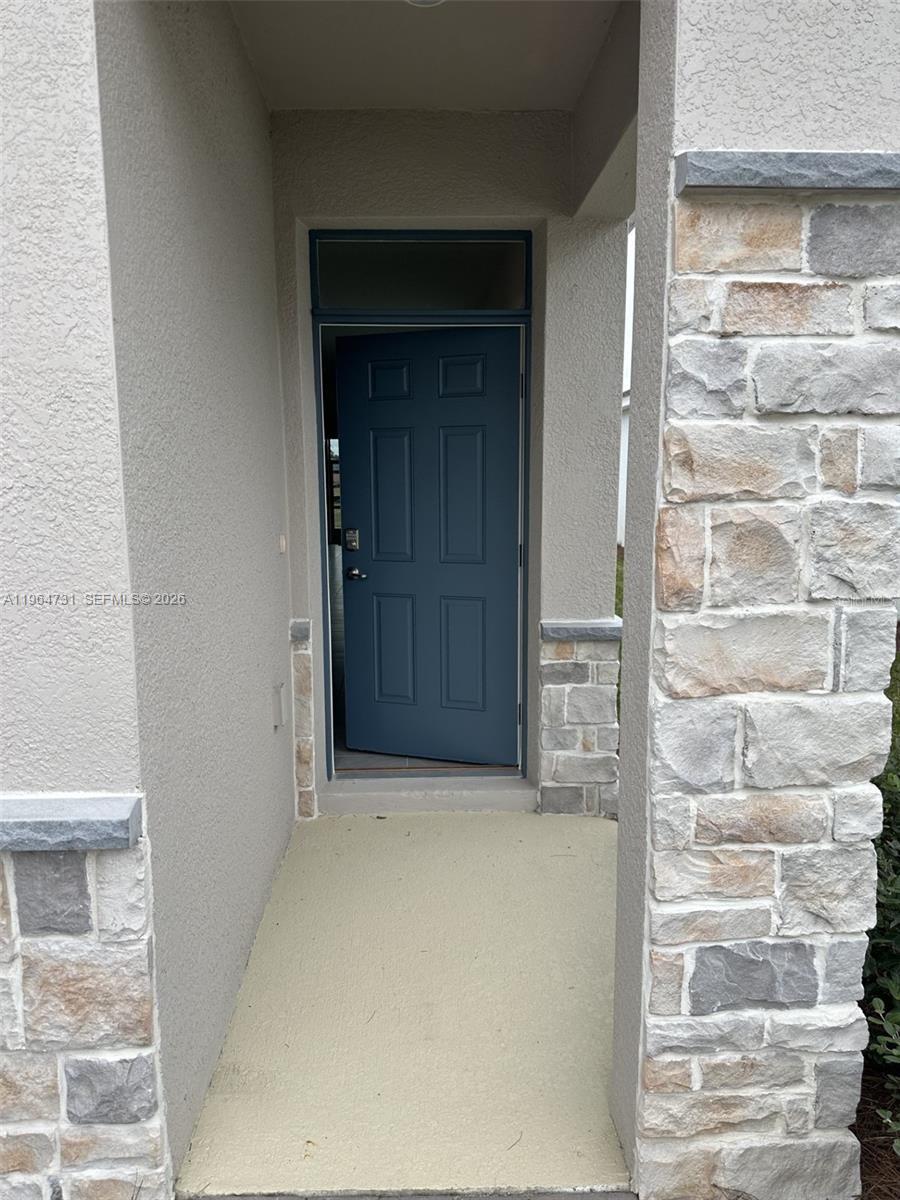 A blue front door is set within a recessed entryway featuring stone veneer accents — 4078 NW 44 CIR # 0, Ocala FL 34482, OCALA, FL