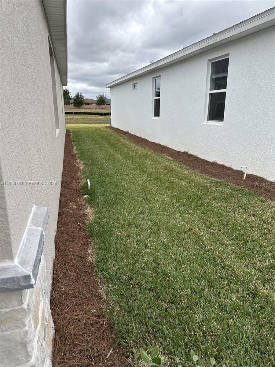 A narrow grassy side yard sits between two white stucco residential buildings — 4078 NW 44 CIR # 0, Ocala FL 34482, OCALA, FL