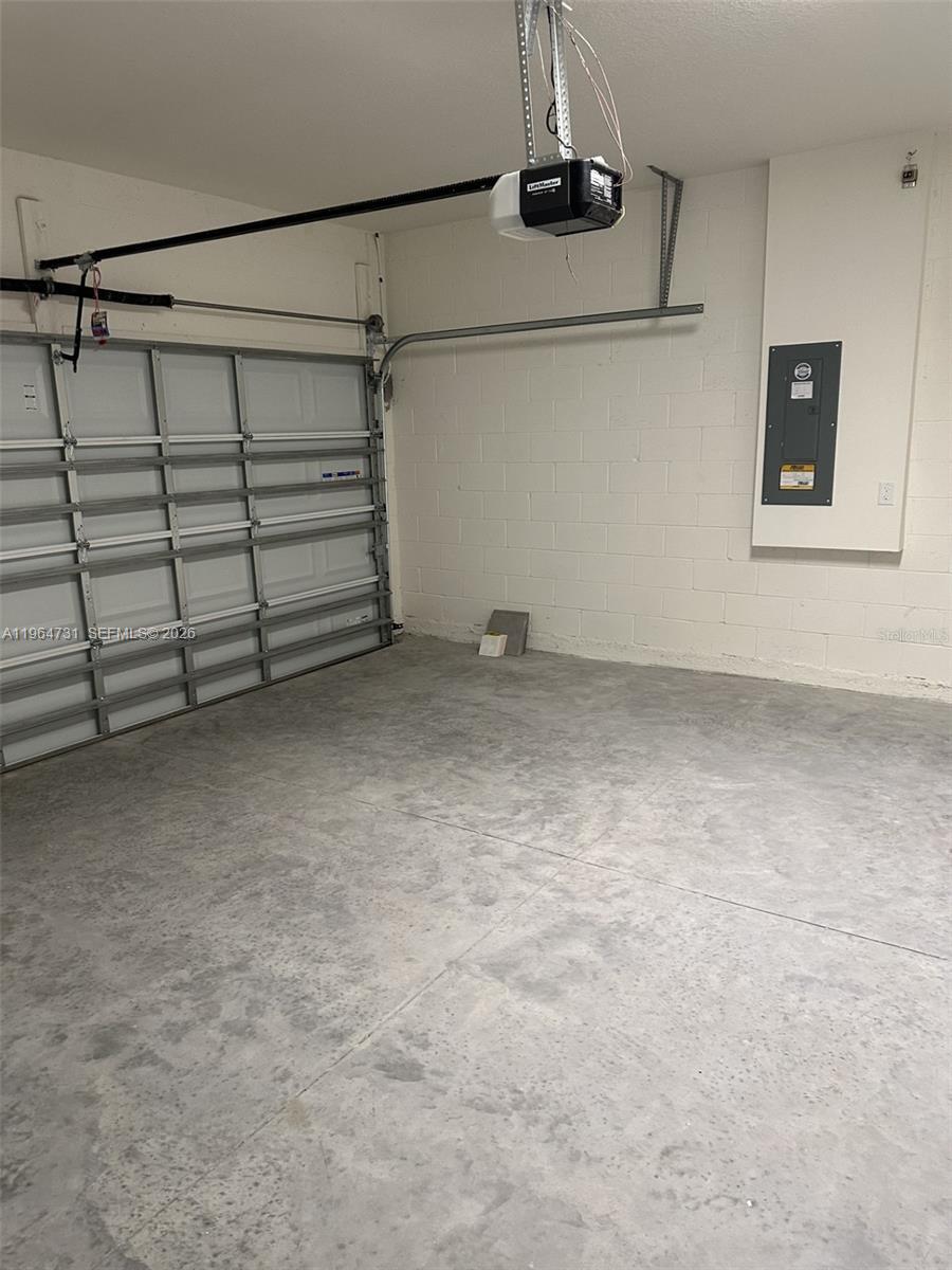 This garage features a concrete floor, a white sectional door, and an electrical panel — 4078 NW 44 CIR # 0, Ocala FL 34482, OCALA, FL
