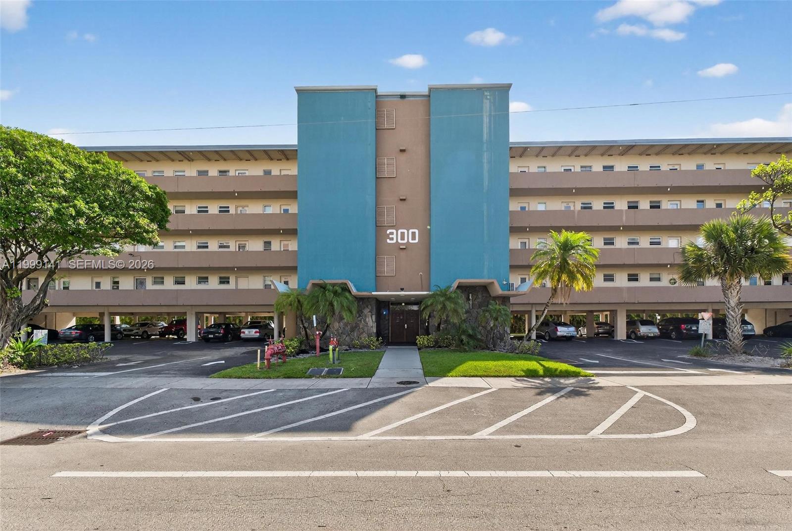 A multi-story apartment building features a central blue facade with the number 300 displayed — 300 NE 14th Ave # 505, Hallandale Beach FL 33009, HALLANDALE BEACH, FL
