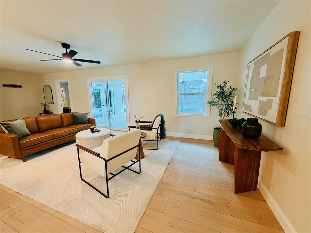 A living room features a leather sofa, two chairs, a console table, and light wood flooring — 25426 SW 18TH AVENUE, NEWBERRY, FL