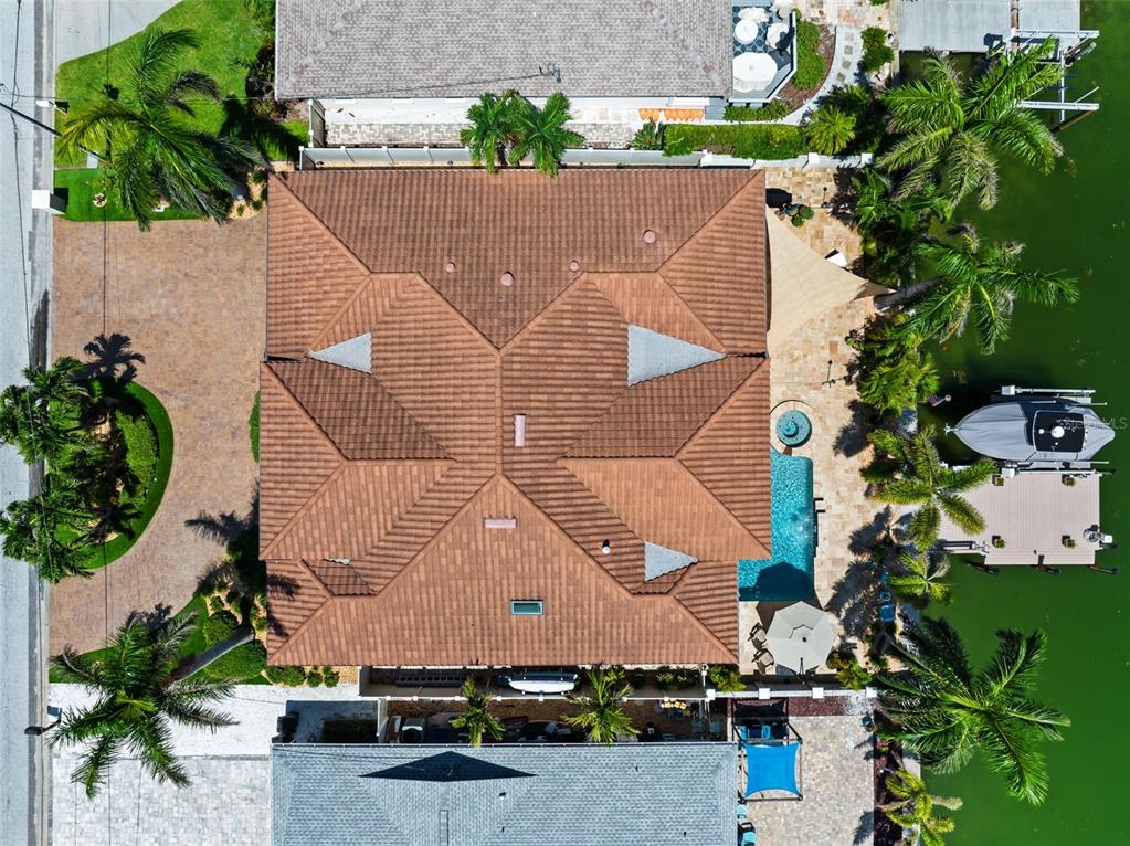 An aerial view of a house with a tiled roof, a pool, and a boat dock — 203 HOWARD DRIVE, BELLEAIR BEACH, FL