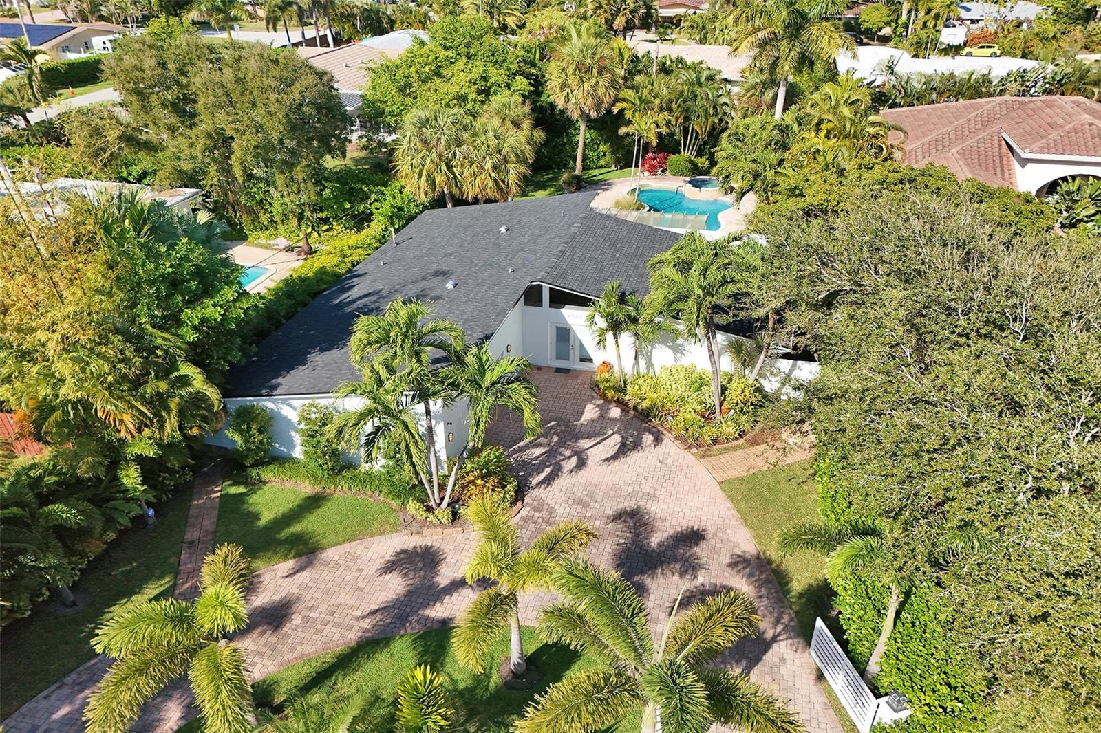 An aerial view of a white house with a dark roof, paved driveway, and pool — 2525 SE 7th Drive, Pompano Beach FL 33062, POMPANO BEACH, FL