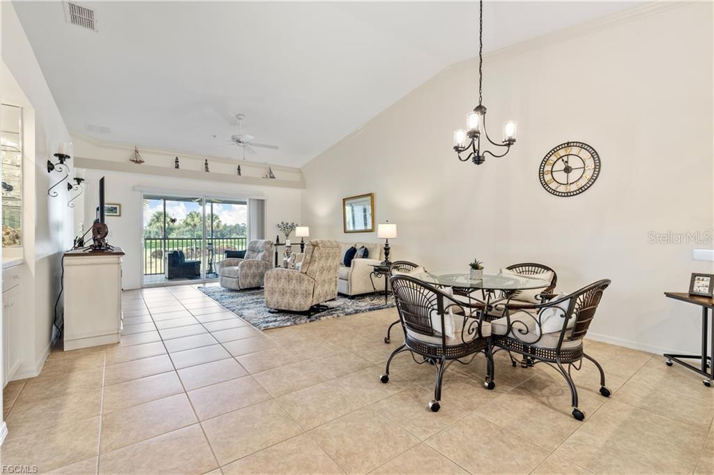 A living and dining area features tile floors, a vaulted ceiling, and a sliding glass door — 10420 WINE PALM ROAD UNIT 5421, FORT MYERS, FL