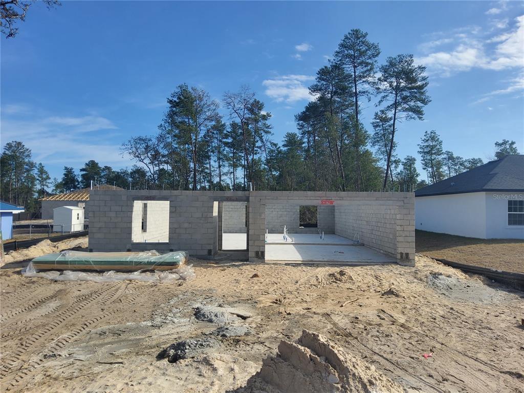 A house under construction with concrete block walls and an open garage area — 5237 SW 165TH STREET ROAD, OCALA, FL