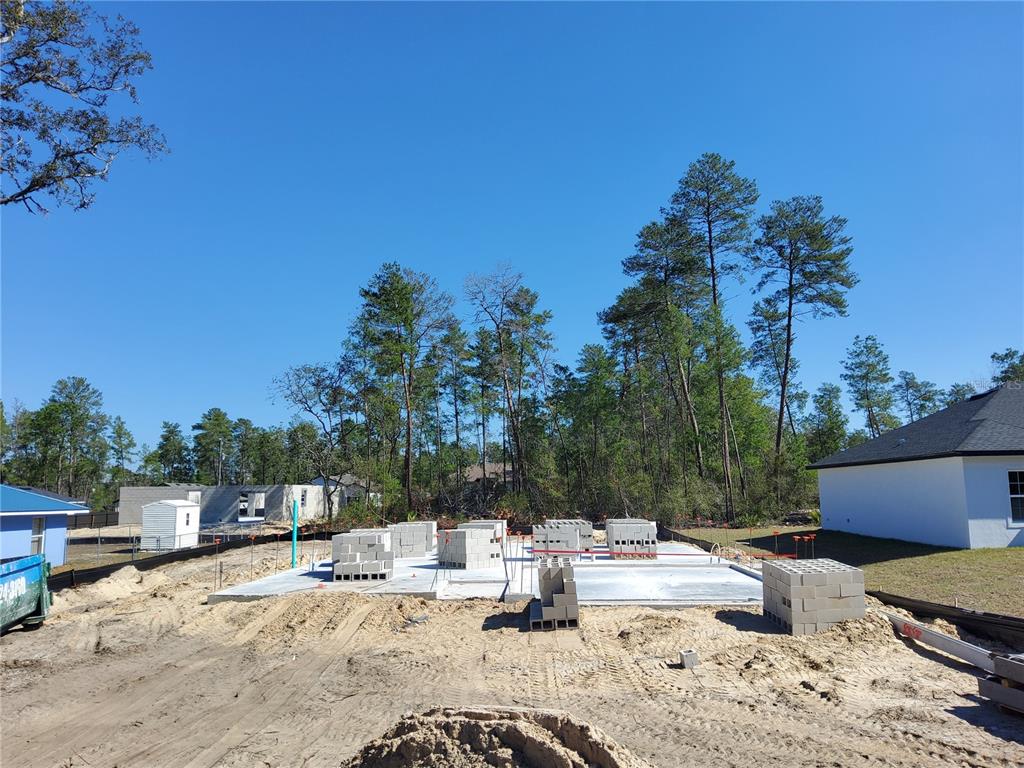 A concrete slab foundation sits on a sandy lot with stacks of construction blocks — 5237 SW 165TH STREET ROAD, OCALA, FL