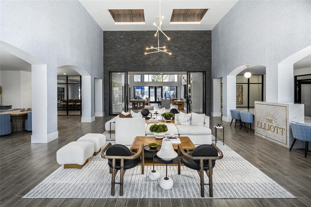 A modern lobby features a large seating area, a dark brick accent wall, and high ceilings — 20191 SABAL PALM COURT UNIT B2, LAND O LAKES, FL