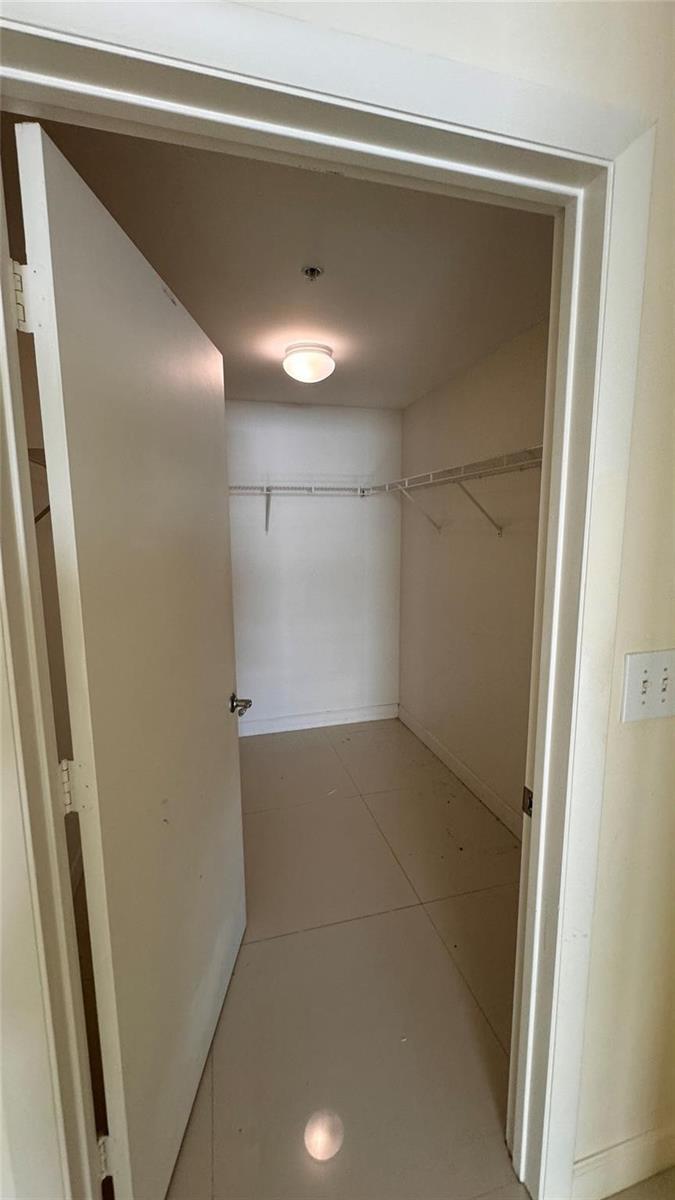 A walk-in closet with tile flooring, white walls, and wire shelving — 253 NE 2nd Street # 3208, Miami FL 33132, MIAMI, FL