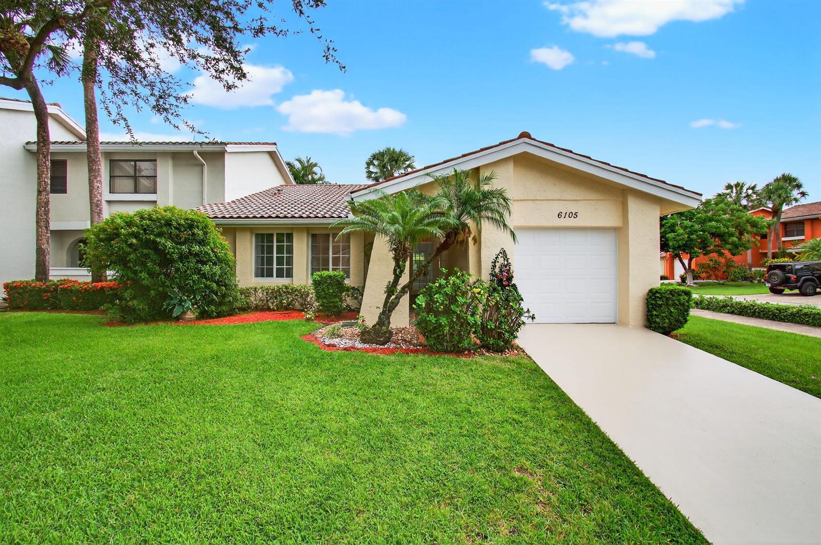 A single-story house with a beige stucco exterior, a tile roof, and a front driveway — 6105 Via Laguna Lane, Boca Raton FL 33433, BOCA RATON, FL