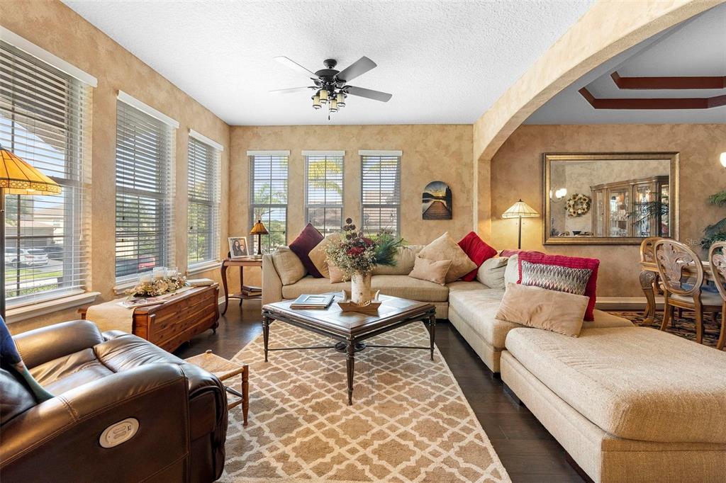 A living room features a beige sectional sofa, a coffee table, and a leather recliner — 3551 STATHAM DRIVE, APOPKA, FL