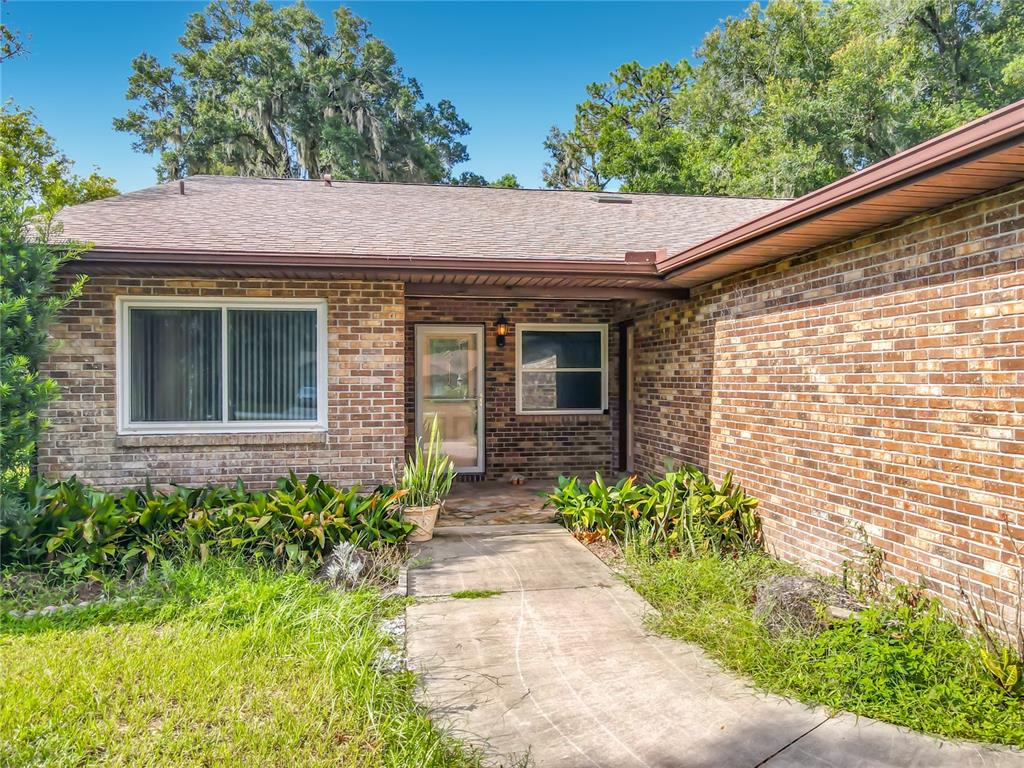 A single-story brick house with a two-car garage and a front walkway — 474 W OAKWOOD AVENUE, ORANGE CITY, FL