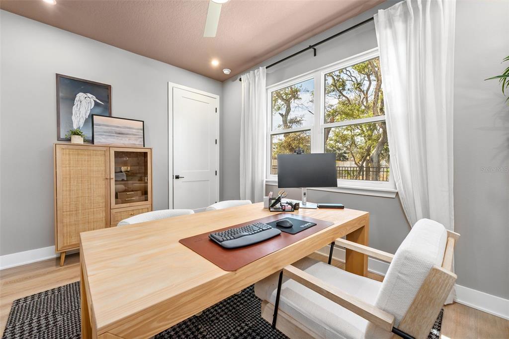 A home office features a light wood desk, a computer monitor, and a rattan cabinet — 2111 TIDEWATCH LOOP, NEW SMYRNA BEACH, FL