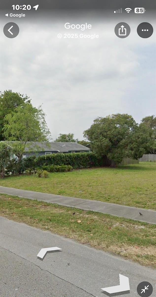 A grassy vacant lot sits next to a house partially obscured by a tall hedge — 132 & 134 NW 6th Avenue, Delray Beach FL 33444, DELRAY BEACH, FL