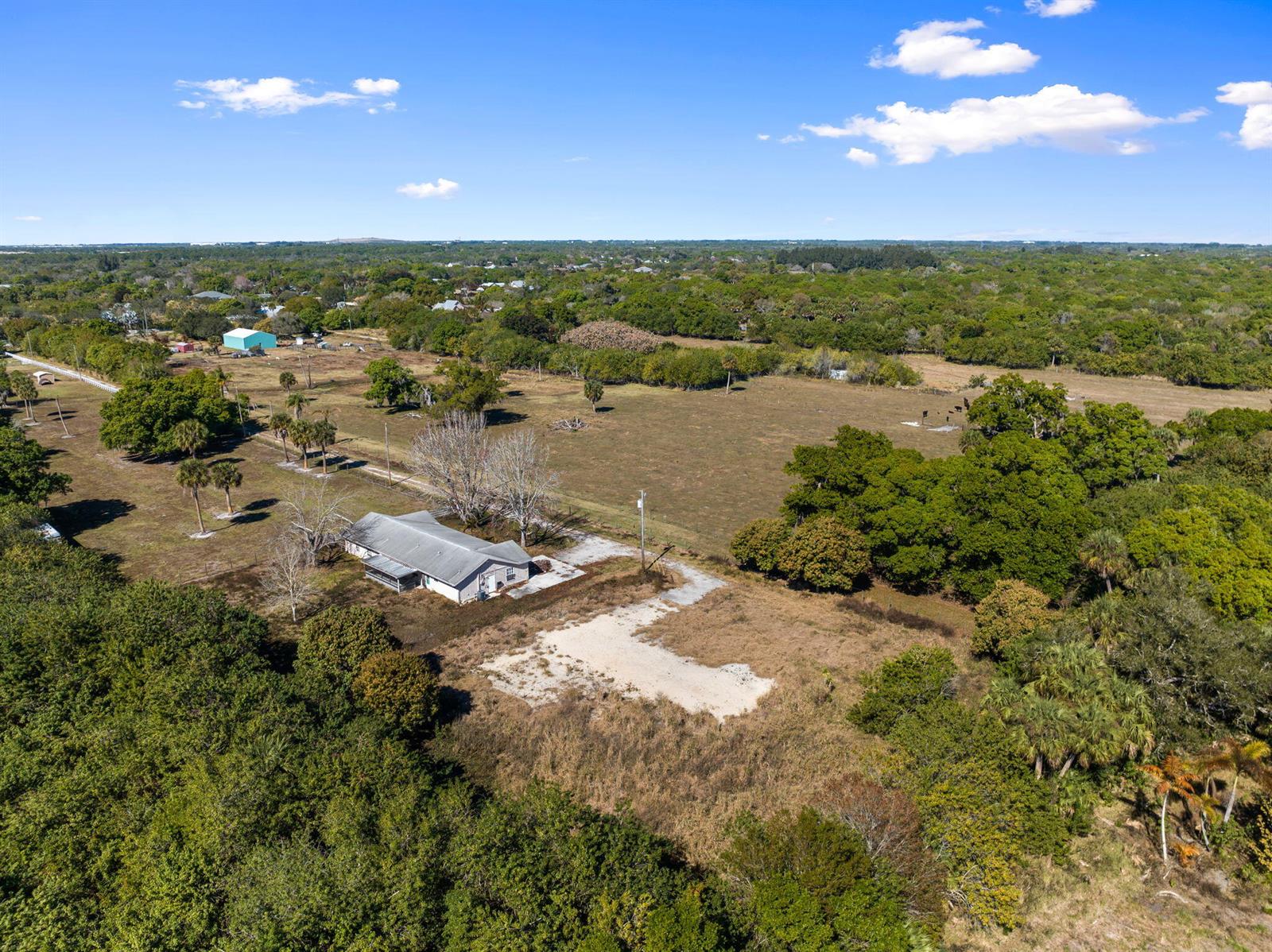An aerial view shows a single-story house on a large, grassy rural property with trees — 6406 Oleander Avenue, Fort Pierce FL 34982, FORT PIERCE, FL