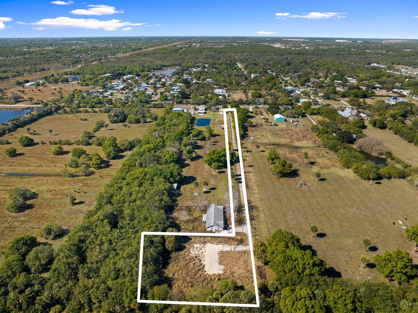 An aerial view shows a rural property with a house and a long driveway — 6406 Oleander Avenue, Fort Pierce FL 34982, FORT PIERCE, FL