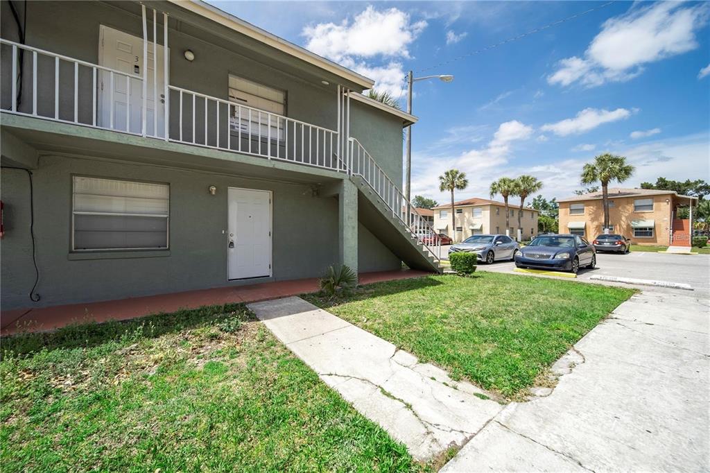 A two-story apartment building with exterior stairs and a concrete walkway — 702 MICHIGAN COURT UNIT 1, ST CLOUD, FL