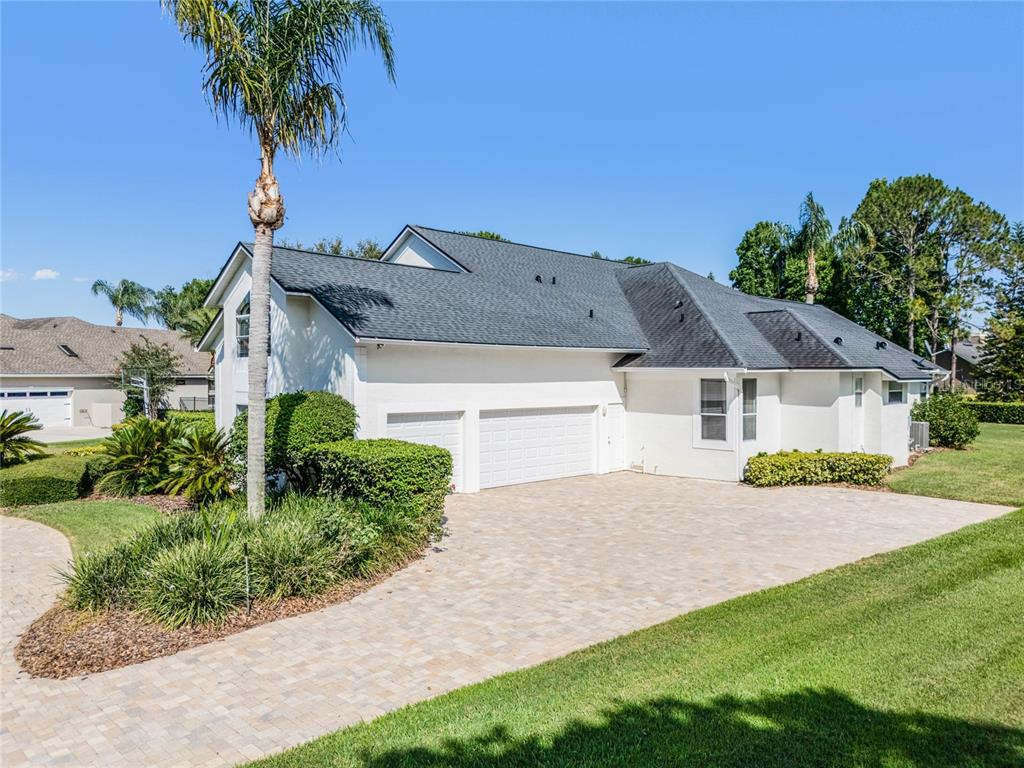 A white house with a dark shingled roof and a paved driveway — 2031 WILLOW LAUREN LANE UNIT L, WINDERMERE, FL