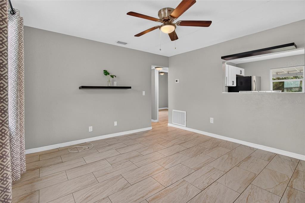 A living room with light gray walls, wood-look tile flooring, and a ceiling fan — 4529 73RD STREET N, ST PETERSBURG, FL